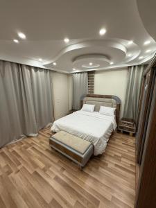ein Schlafzimmer mit einem großen Bett und Holzböden in der Unterkunft فيلا مع حمام سباحه وجاردن 0306-888-0106 in Kairo