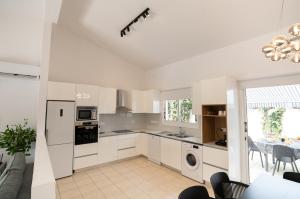 a kitchen with white cabinets and a table and chairs at Villa Adela Coral-Bay 3B, Private Pool, Seaside in Peyia +69 photos