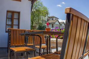 a table and chairs on a balcony with a house at Old Bazaar 1790 in Gjirokastër