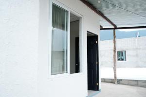 a white house with a window and a door at Hostal Casa Ale in San Juan La Laguna