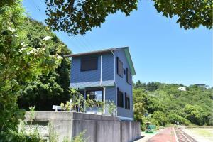 a blue house on top of a concrete wall at シーサイド興津 in Sanuki