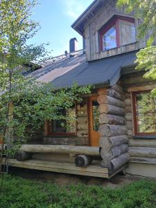 a log cabin with a porch and a window at Holiday Home Lumikieppi in Äkäslompolo