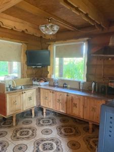 a kitchen with a sink and a tv and windows at Guest House Väikesaare in Narva