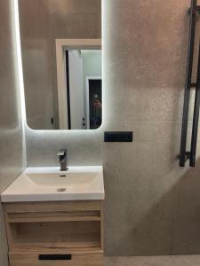 een badkamer met een wastafel en een spiegel bij 13 mountains in Bisjkek