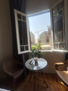 une petite table dans une pièce avec une fenêtre dans l'établissement New Havana Hotel, au Caire