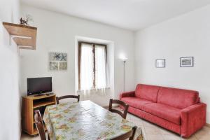 sala de estar con sofá rojo y mesa en Famiglia Ricci, en Marina di Campo