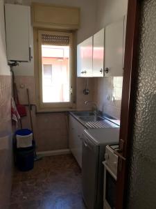 Una pequeña cocina con fregadero y ventana. en Silvi Appartamento fronte-mare, en Silvi Marina