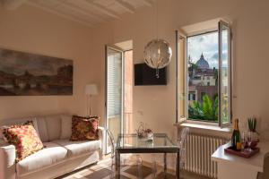 un soggiorno con divano e tavolo in vetro di La Porta Rossa di Borgo - Vatican Luxury Suite a Roma