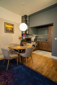 a dining room with a table and chairs and a kitchen at The Nest in Ruse