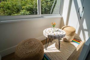 a small table with a vase on it next to a window at The Nest in Ruse