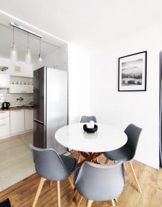 a kitchen with a table and chairs and a refrigerator at Rynek Golden Stay by Grafit in Legnica