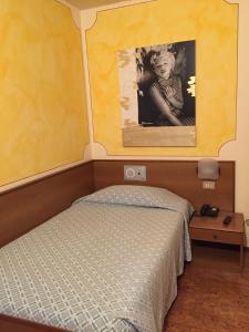 a bedroom with a bed and a picture of a woman at Hotel da Rita in Condino +86 photos