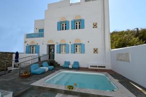 a villa with a swimming pool in front of a house at Tinos Aqua Palazzo in Tinos