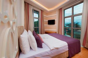 a bedroom with a bed with pillows and a window at Wes Hotel in Kocaeli +37 photos