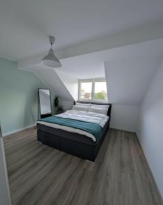 a bedroom with a bed in a white room at Traumwohnung über den Dächern Rüttenscheids in Essen