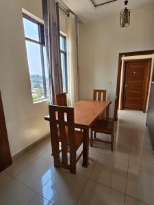a dining room with a wooden table and chairs at Golden Flame in Kigali +15 photos