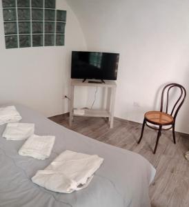 a bedroom with a bed with a chair and a television at Casa Vacanza Altamura in Altamura