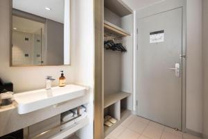 a bathroom with a sink and a mirror and a shower at Magnotel Harbin Medical University First Affiliated Hospital in Harbin +117 photos