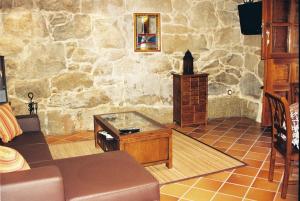 sala de estar con mesa y pared de piedra en Casa Noelmar, en Combarro