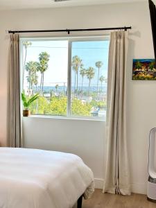 1 dormitorio con una gran ventana con palmeras en Modern 5BR Luxury Paradise Villa, en Los Ángeles