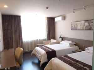 ein Hotelzimmer mit zwei Betten und einem Fenster in der Unterkunft Jinjiang Inn Select Beijing Miyun Development Zone in Miyun + 176 Fotos