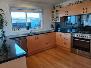 a large kitchen with wooden cabinets and a window at Brightwater Beauty in Brightwater
