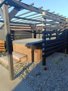 a wooden pergola with a hot tub in a yard at Brightwater Beauty in Brightwater