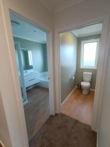 an empty bathroom with a toilet and a window at Brightwater Beauty in Brightwater
