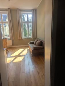 索林根Gästehaus LeLo 6的带沙发和两扇窗户的客厅 更多11张照片