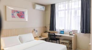 a hotel room with a bed and a desk and a window at Jinjiang Inn Beijing Conference Center Bird Nest in Beijing +97 photos