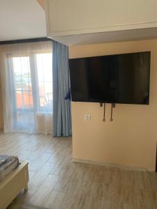 a living room with a large flat screen tv on the wall at Къща за гости DOSH in Sozopol