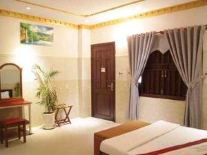 a bedroom with a bed and a table and a window at Au Lac Hotel in Thu Dau Mot +87 photos