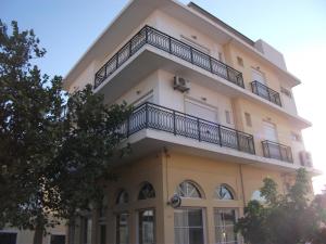 un edificio con balcón en la parte superior en Platanos Rooms, en Agia Marina