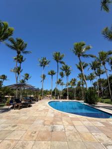 a swimming pool with palm trees in the background at Chalé Paraíso, Praia da Pipa in Pipa