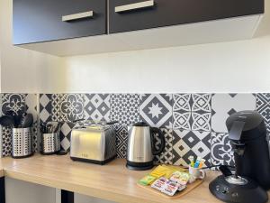 a kitchen counter with a coffee maker and a blender at Le Phare in Calais