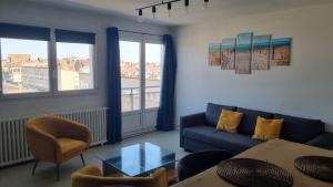 a living room with a couch and a table at Le Phare in Calais