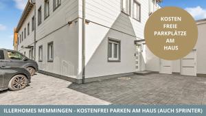 un edificio con un coche aparcado al lado en Iller Homes Memmingen - 3 x Moderne Fewos mit Terrasse für bis zu 7 Pers mit Parkplätzen, en Memmingen