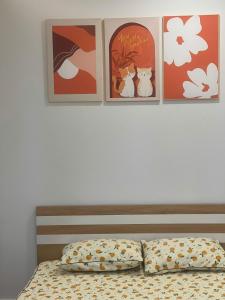 a bed with four pictures on the wall above it at The Rose House-Lakeview Long Bien in Hanoi