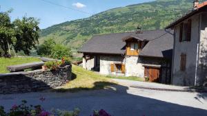 une maison en pierre avec une montagne en arrière-plan dans l'établissement Le Chalet d'Augusta, à Bourg-Saint-Maurice
