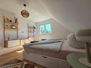 a bedroom with a bed and a window and a table at Ferienhaus am See mit Sauna in Rheinsberg +19 photos