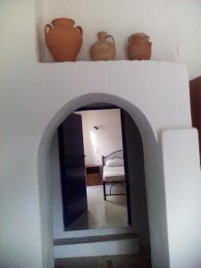 a hallway with a mirror and vases on top of it at Iliana's Bungalow in Arménoi