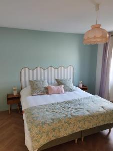 a bedroom with a bed with a pink pillow on it at Gîte L'Apothicaire in Montaigu-Vendée