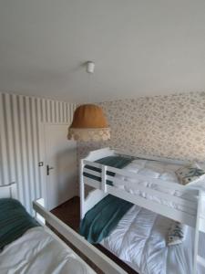 a bedroom with two bunk beds and a lamp at Gîte L'Apothicaire in Montaigu-Vendée +44 photos