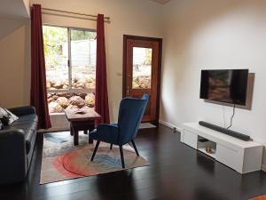 a living room with a blue chair and a television at Kent River Retreat in Kentdale