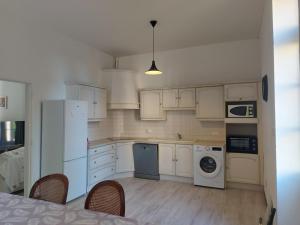 a kitchen with white appliances and a table and chairs at La maison de Valentine in Theneuille