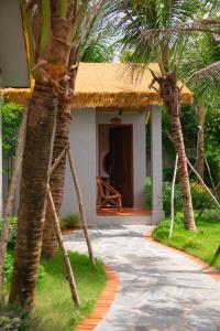 a house with a thatched roof and a walkway leading to it at Forest Home Phú Quốc in Phu Quoc +24 photos