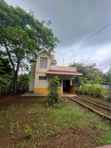 a small house with a train tracks in front of it at Pruthvi Bungalow - EcoFriendlyTourism - efl in Agashi