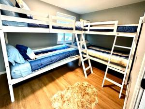 a bedroom with two bunk beds and a ladder at Pocono Mountain Escape - Steps to Lake- Hot Tub - Games- 9 Mins to Ski Slopes! in Long Pond +24 photos