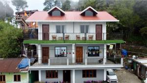 a large white house with a red roof at Guras Homestay Chimney in Darjeeling