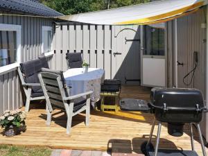 a backyard patio with a table and a grill at 6 person holiday home in Löderup in Löderup